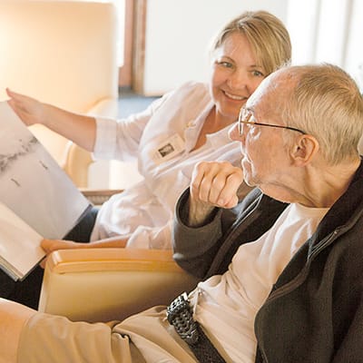 Staff member reading with a resident in a common area