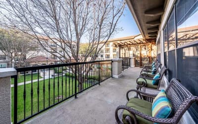 Balcony view with seating overlooking landscaped courtyard