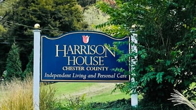 Harrison House sign with landscape backdrop.