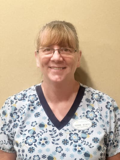 Staff member smiling in a work uniform.