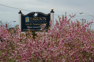 Sign for Harrison Senior Living surrounded by flowers