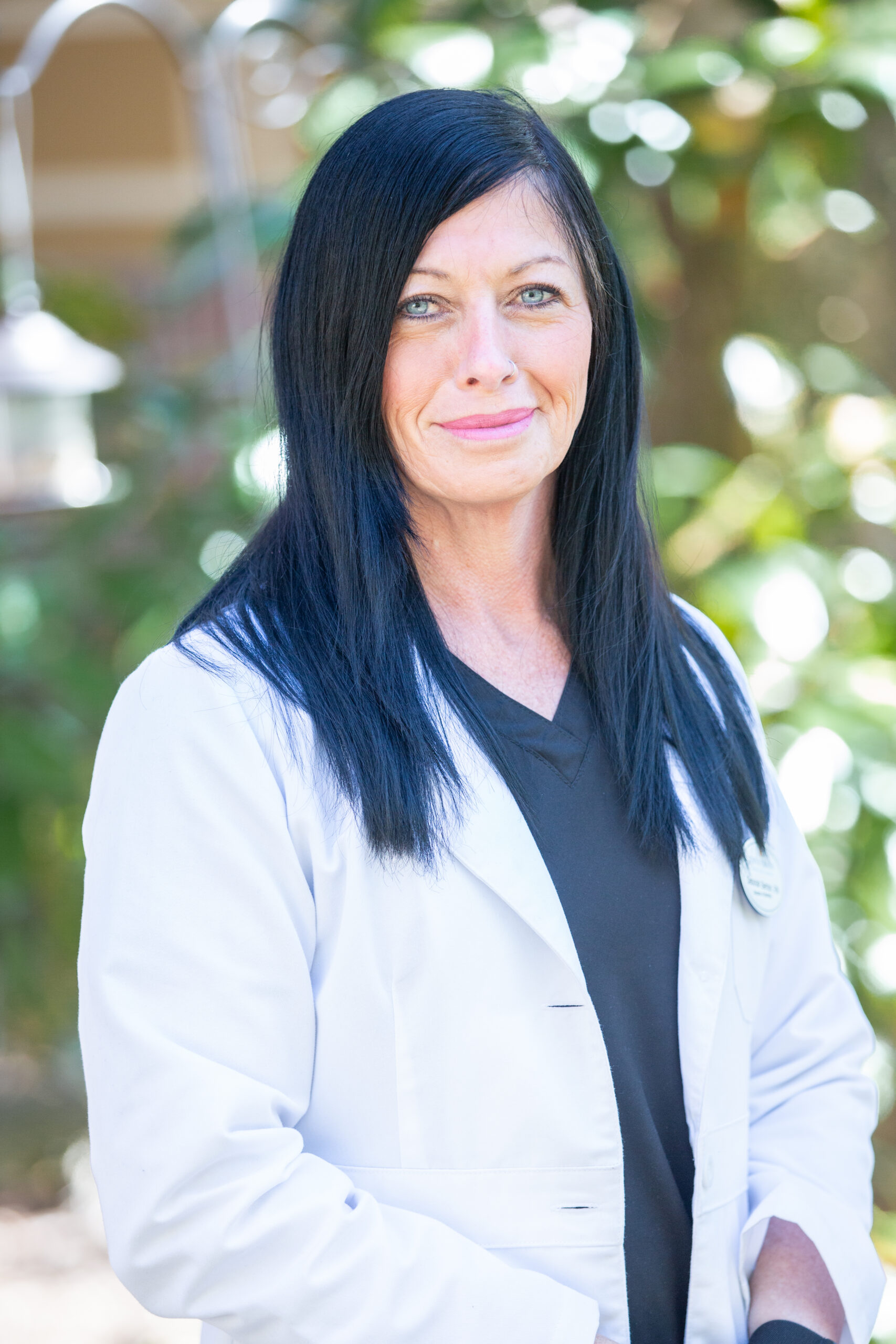 A staff member in a white coat outdoors