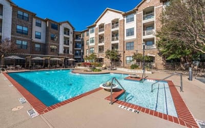 Outdoor pool area with lounge chairs and facility building