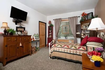 Cozy resident room with a quilted bed and decor
