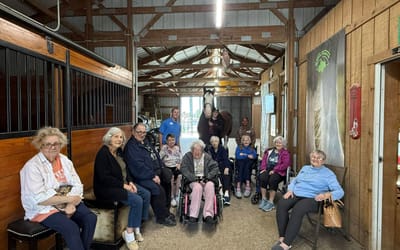 Residents interacting with staff in a barn setting