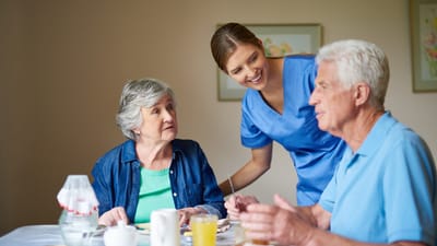 Residents interacting with staff in a dining area