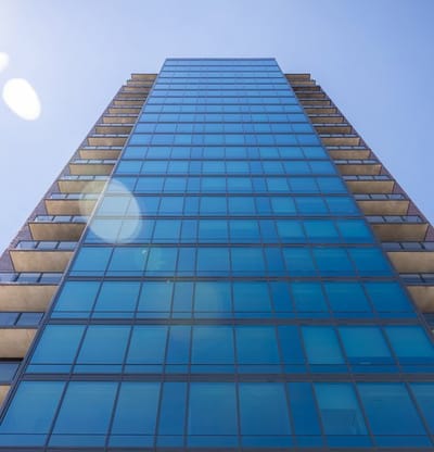 Tall building with glass facade under blue sky