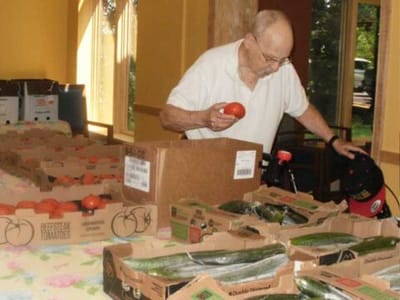 An elderly man sorting vegetables indoors