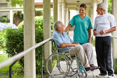 Care staff interacting with residents in a garden area