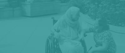 A caregiver talking with a resident in a garden area