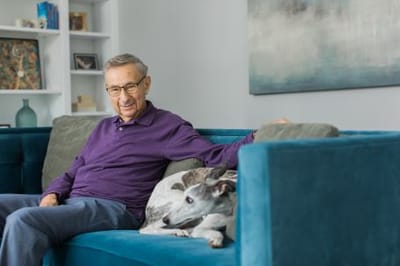 Senior man relaxing on a couch with a dog