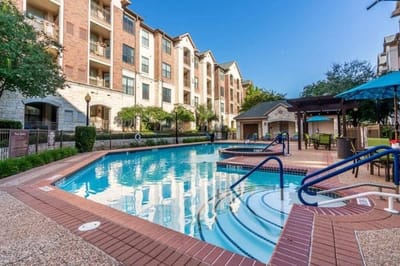 Outdoor pool area with surrounding residential building
