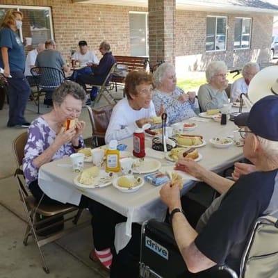 Residents enjoying a meal outdoors at a dining event