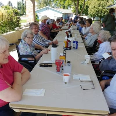 Residents enjoying time outdoors at a long table