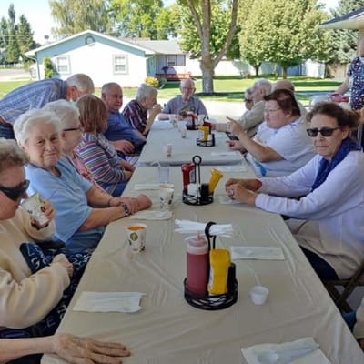 Residents enjoying a meal outside at a long table