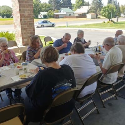 Residents enjoying a meal outdoors at tables