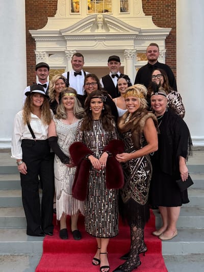 Staff and residents dressed up for a themed event on the steps of the facility