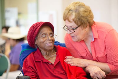 A caregiver interacting warmly with a resident in a facility setting