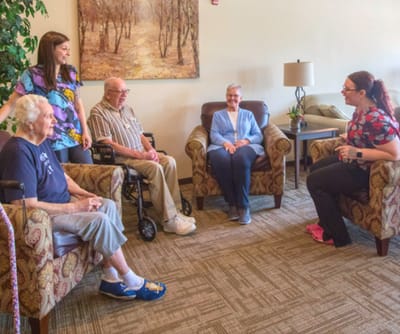 Residents and staff engaging in a conversation in a cozy common area