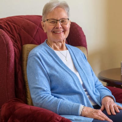 Senior woman smiling in a cozy chair
