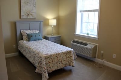 Cozy resident room with floral bedding and a lamp