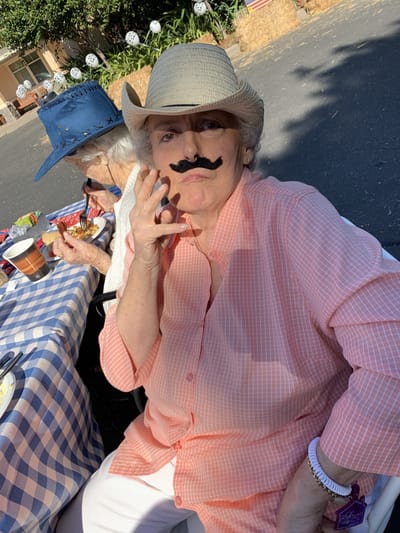 Resident posing with a funny mustache at an outdoor event