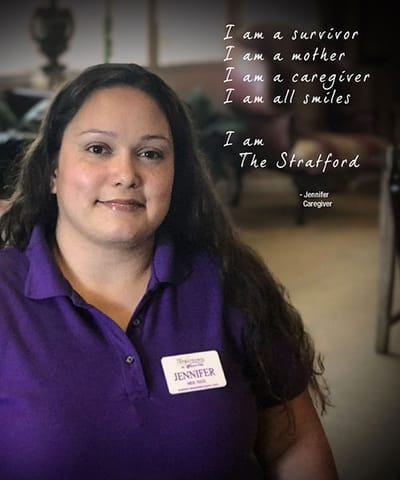 A caregiver in a purple shirt with a name tag