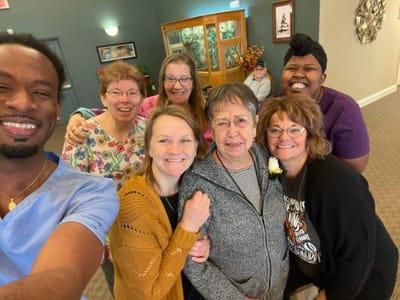Residents and staff posing together in a common area
