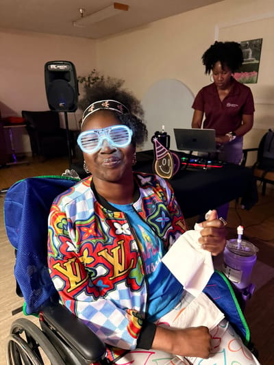 Resident enjoying a celebration with colorful sunglasses