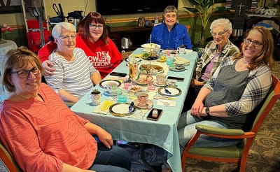 Residents and staff enjoying a tea party together