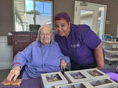 Resident and staff member smiling together in a common area