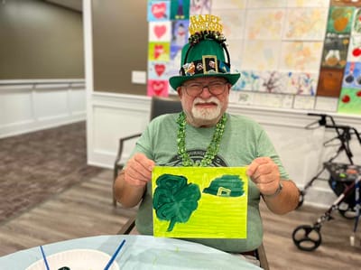 Senior resident showing off artwork during a celebration