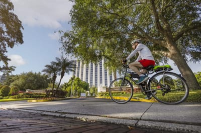 A resident cycling on a path near the facility building
