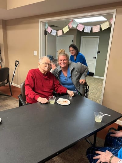 Resident and staff enjoying a snack together in the facility