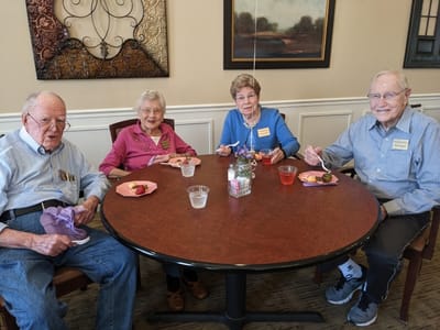 Four residents enjoying dessert in a dining area