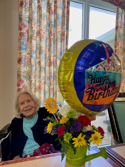 Resident celebrating birthday with balloon and flowers