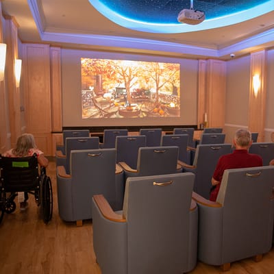 Residents enjoying a movie in a cozy theater