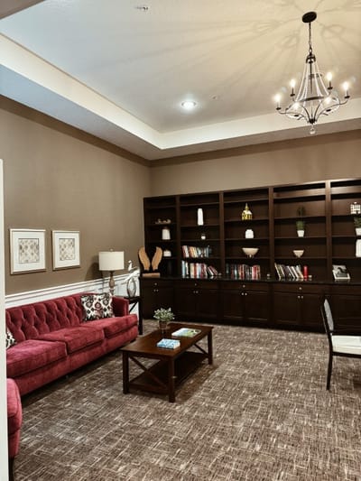 Cozy interior lounge with a red sofa and bookshelves