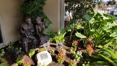 Outdoor garden statue of a couple among plants
