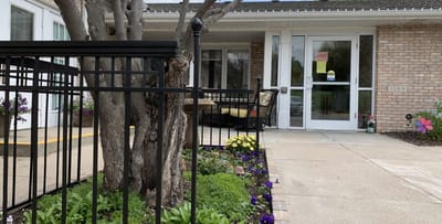 Outdoor entrance with flowers and seating area