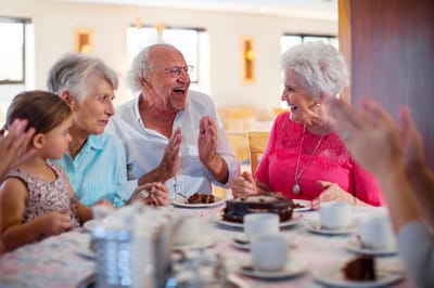 Residents celebrating with cake and joyful interaction