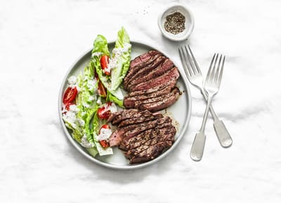 A plate of grilled steak with salad