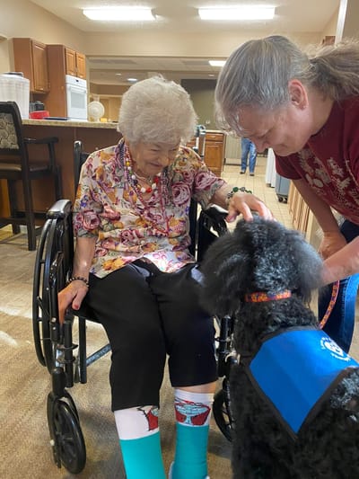 Resident interacting with a therapy dog in a common area