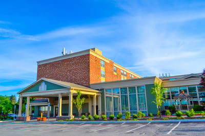 Exterior view of the senior living facility with gardens