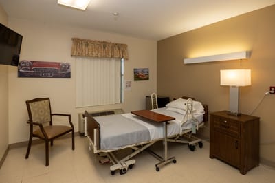 Private resident room with adjustable bed and seating