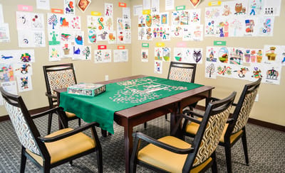 Activity room with puzzles and children's artwork on the walls