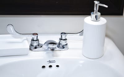Close-up of a bathroom sink with soap dispenser