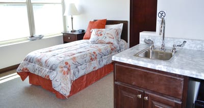 A cozy private resident room with a bed and kitchenette