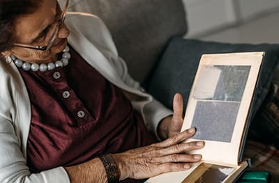 An elderly woman looking at a photo album