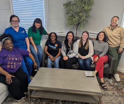 Staff members and residents smiling together indoors.